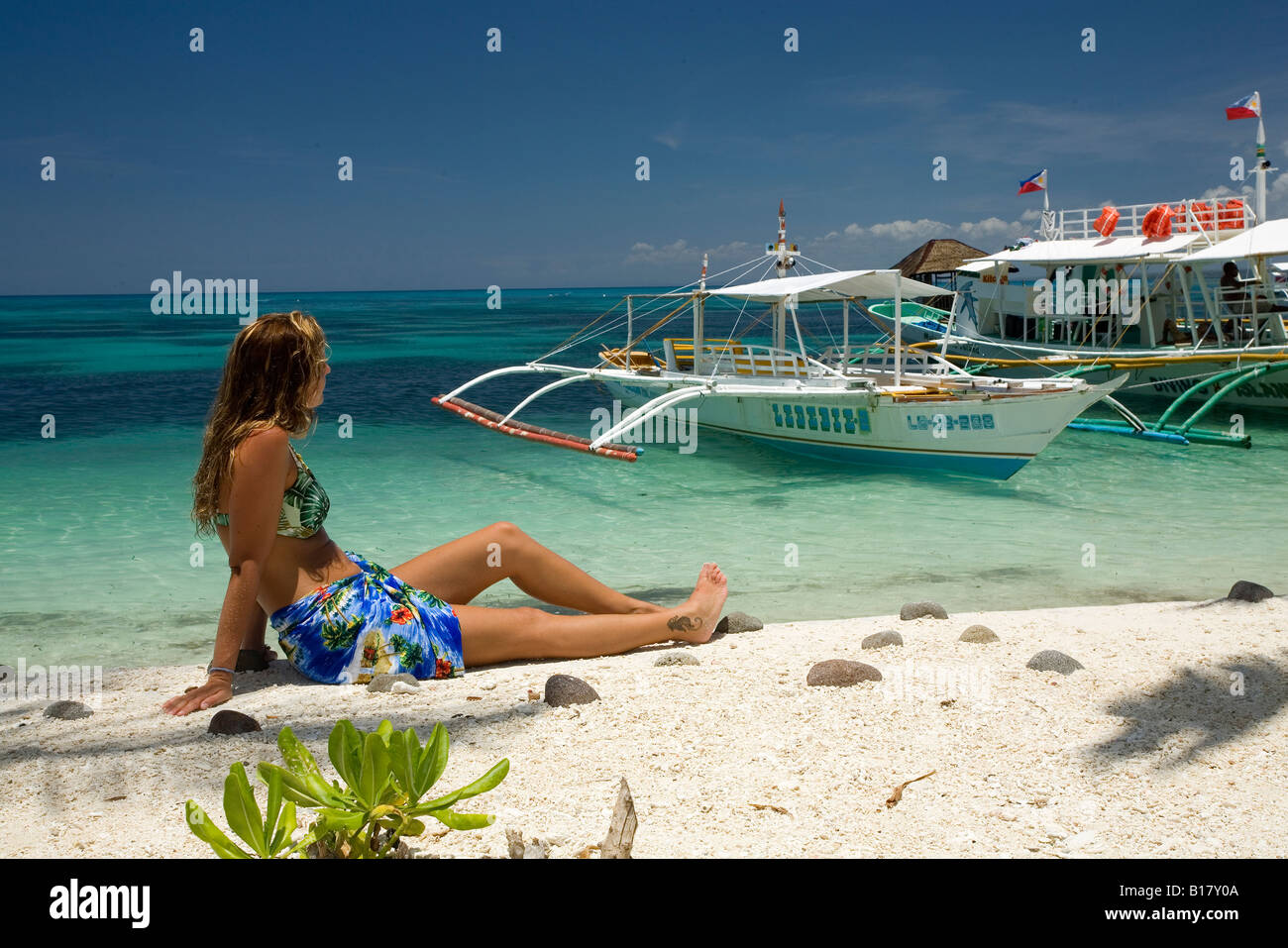 Touristen am Strand mit einigen Bangka Insel Malapascua Cebu Philippinen Stockfoto