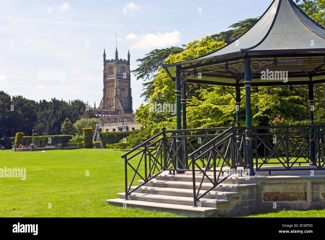 Der Turm von der Pfarrei Kirche des St. Johannes des Täufers gesehen aus dem Kloster-Gelände in Cirencester, Gloucestershire, England Stockfoto