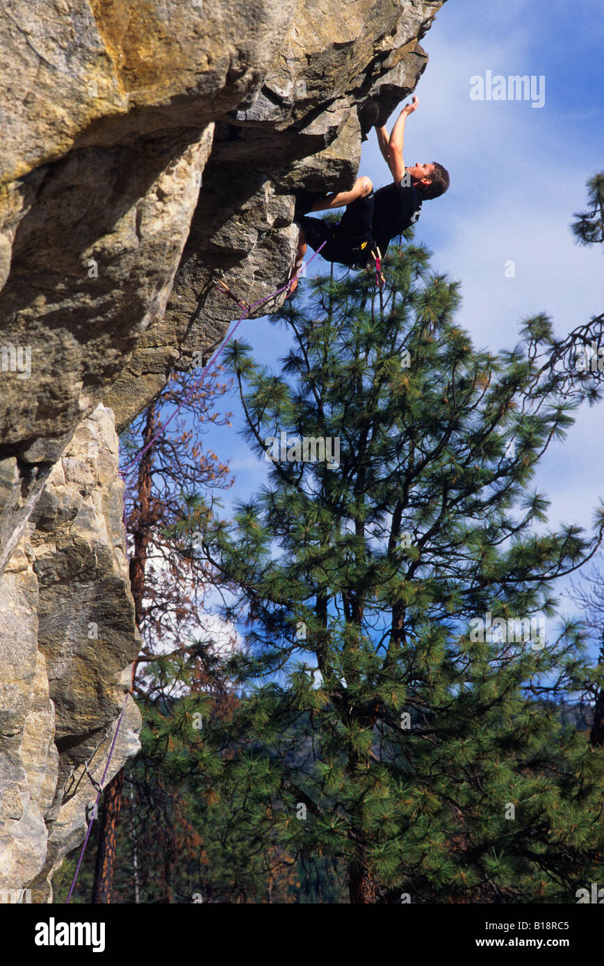 Mann an der Welle Wand klettern. Skaha Bluffs. Penticton, Britisch-Kolumbien, Kanada. Stockfoto