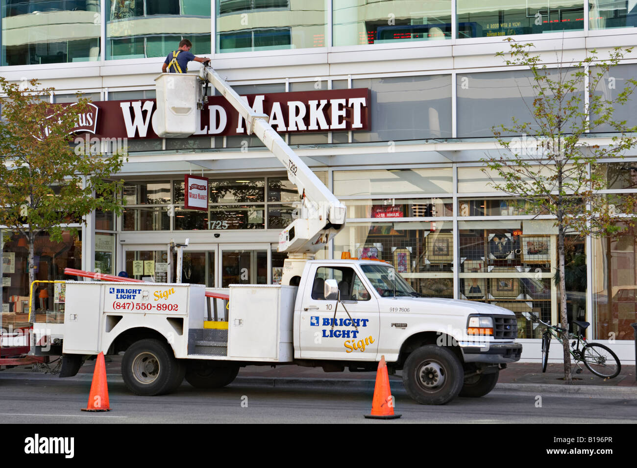 Arbeiter Evanston Illinois Mann in Hubarbeitsbühnen Eimer arbeiten an Zeichen für Retail Store Kosten Plus Weltmarkt Stockfoto