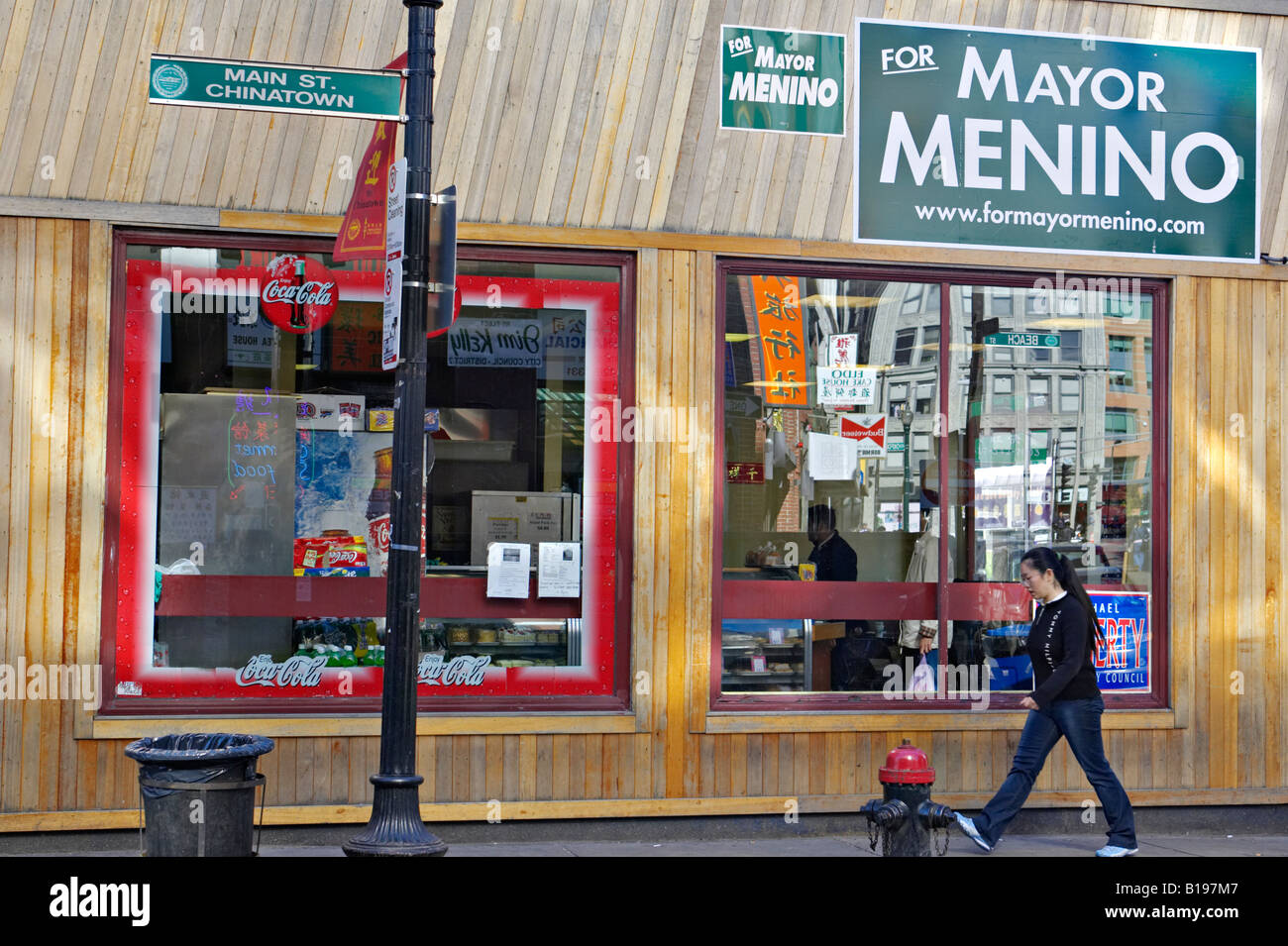 MASSACHUSETTS Boston Frau auf Bürgersteig Spaziergang vorbei an Restaurants und Geschäfte in Chinatown Bezirk Main Street politische Plakate Stockfoto