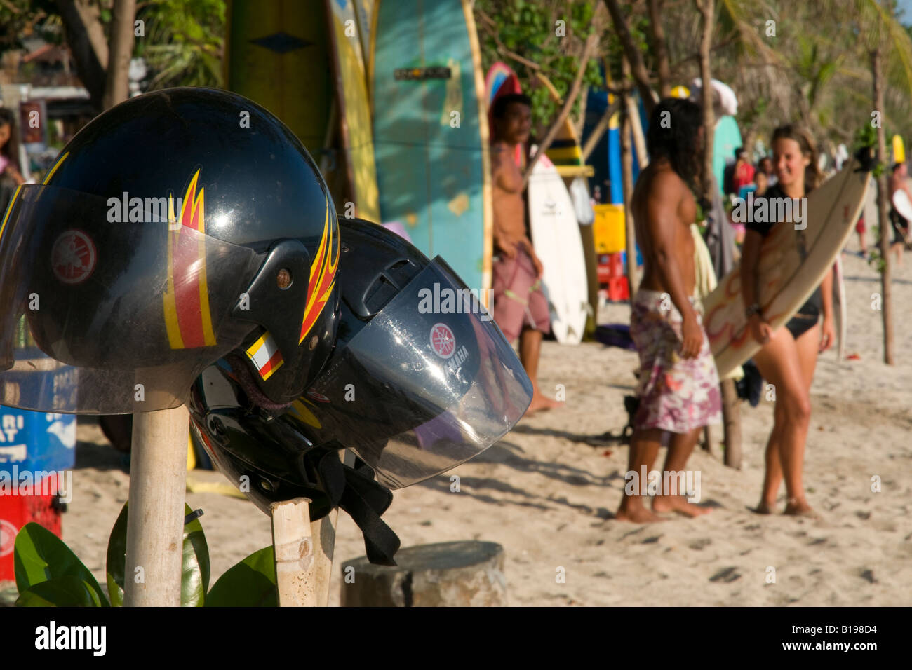 Indonesien Bali Island Kuta Strand surfen schließen sich der Helme mit Frau, die ihr Surf-Board in Bkgd Stockfoto
