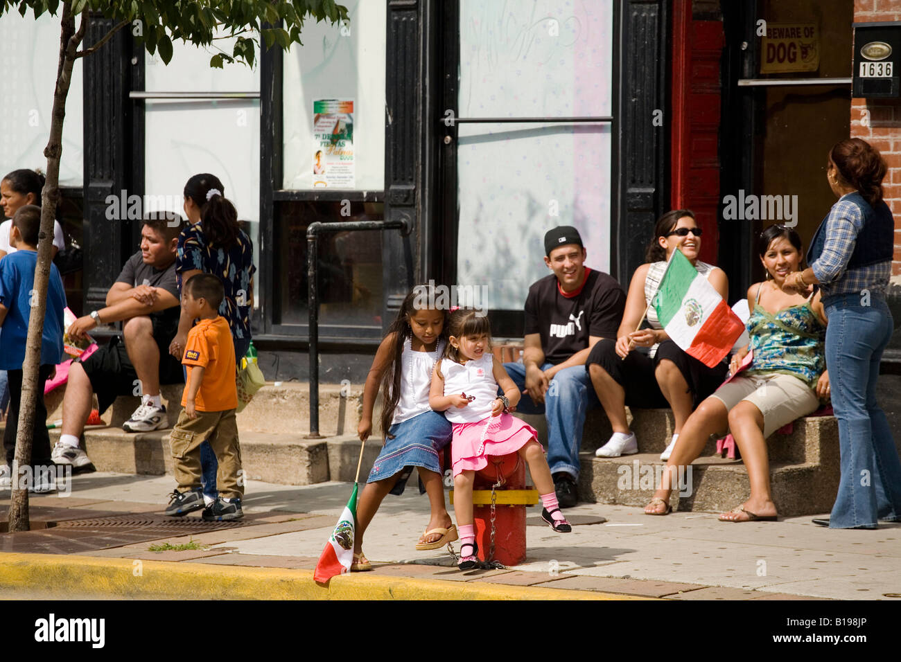 ILLINOIS-Chicago-Kinder sehen Sie mexikanische Independence Day Parade in Pilsen Nachbarschaft Menschen neigt zu sitzen Stockfoto