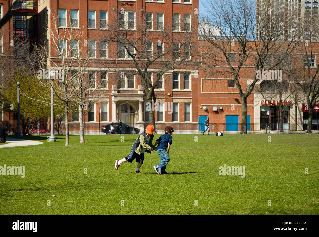 CHICAGO Illinois Kinder spielen in Wiese zwei jungen Tag Abspielen im städtischen Park Altstadt-Viertel Stockfoto