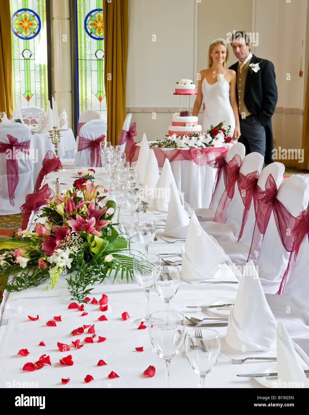 England, Nordirland, Londonderry. Braut und Bräutigam posieren für Bilder von ihrer Hochzeit Kuchen am Tag ihrer Hochzeit. Stockfoto