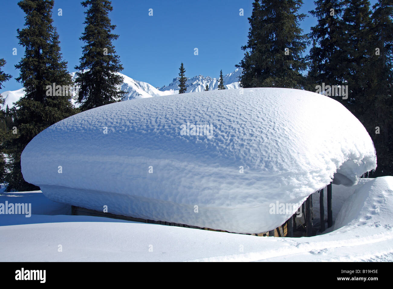 USA, Alaska. Ein kleines Blockhaus in die Alaska Range ist im zeitigen Frühjahr mit Schnee bedeckt. Stockfoto