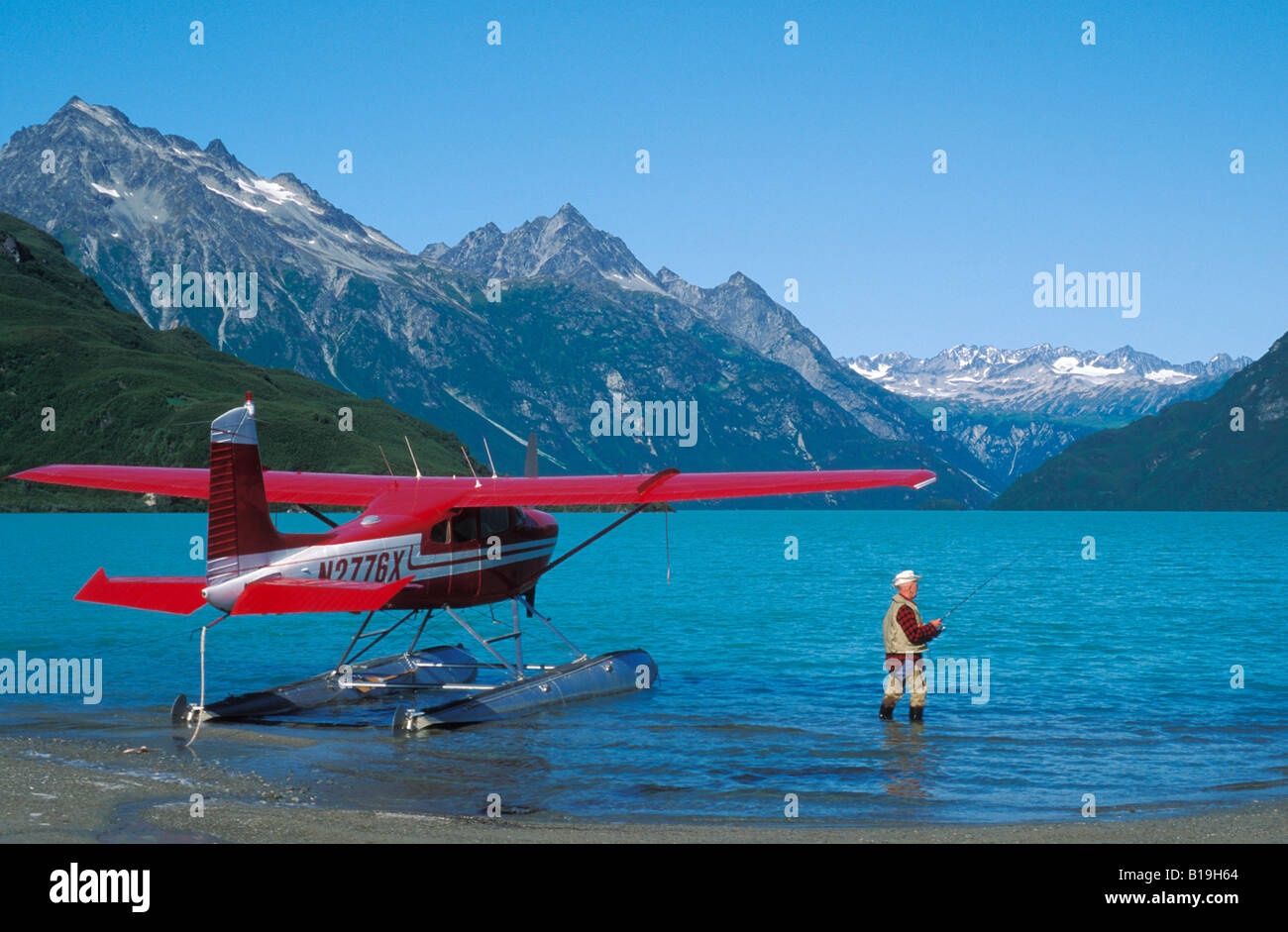 USA, Alaska, Lake Clark National Park. Yogi Kaufman fischt für Lachs neben einem Flugzeug Cessna 180 in Crescent Lake. Stockfoto