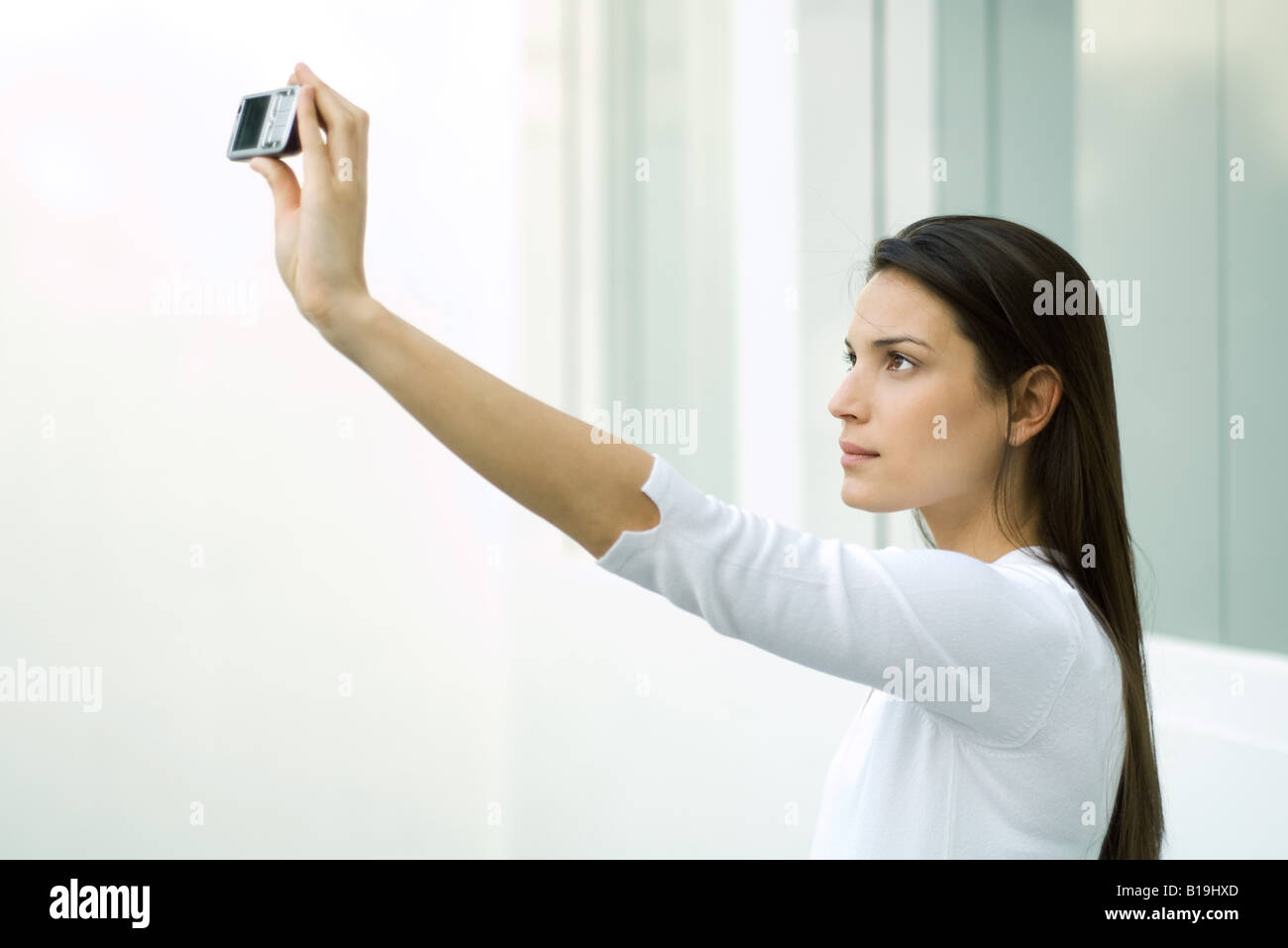 Frau fotografieren sich mit Schalltrichter, erhobenem arm Stockfoto