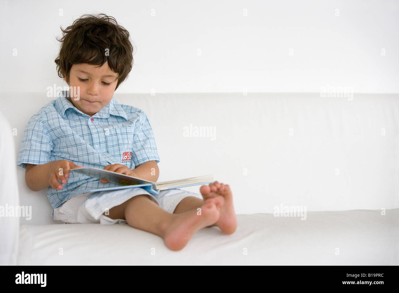 Kleinkind, die vorgibt, ein Buch zu lesen Stockfoto
