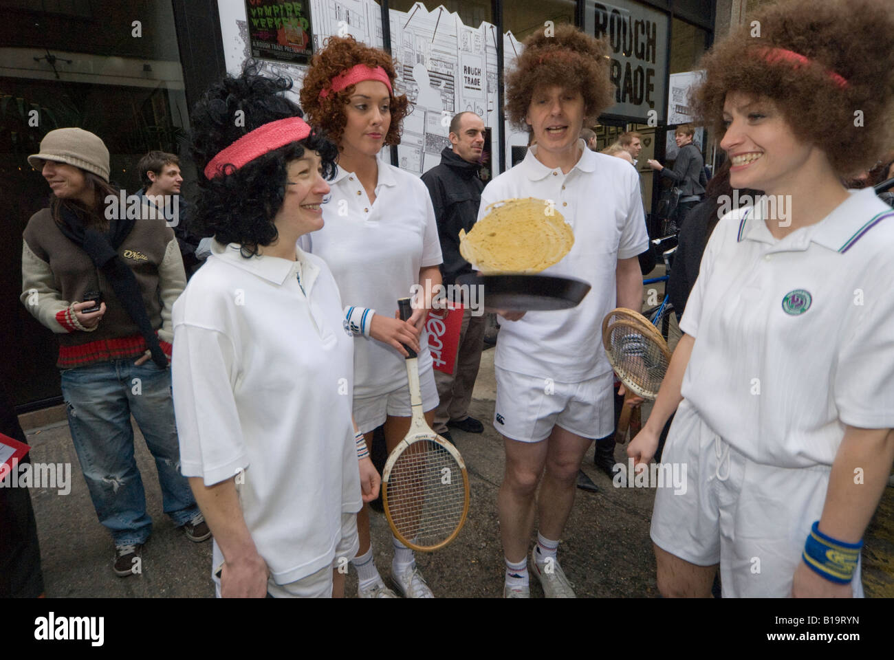 Konkurrenten in der Great Spitalfields Pancake Race-Praxis die Pfannkuchen vor dem Rennen zu werfen. Stockfoto