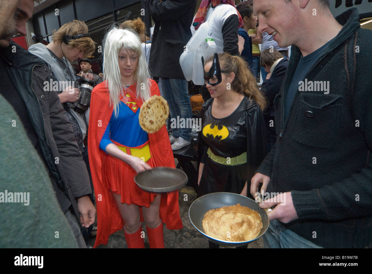 Konkurrenten in der Great Spitalfields Pancake Race-Praxis die Pfannkuchen vor dem Rennen zu werfen. Stockfoto