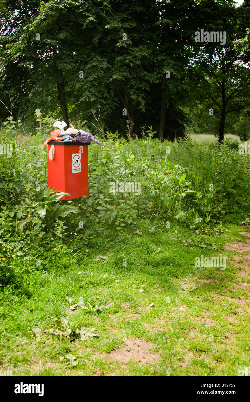 Sehr stinkende und überquellenden Hundeabfallbehälter neben einem Fußweg auf dem Lande Stockfoto