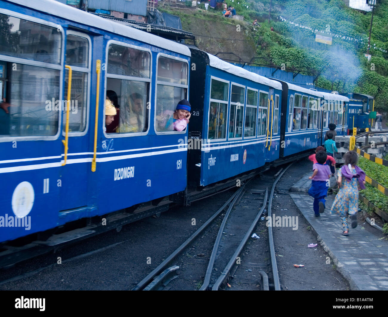 Kinder die Spielzeugeisenbahn zu jagen, als es die Station in Darjeeling verlässt Stockfoto