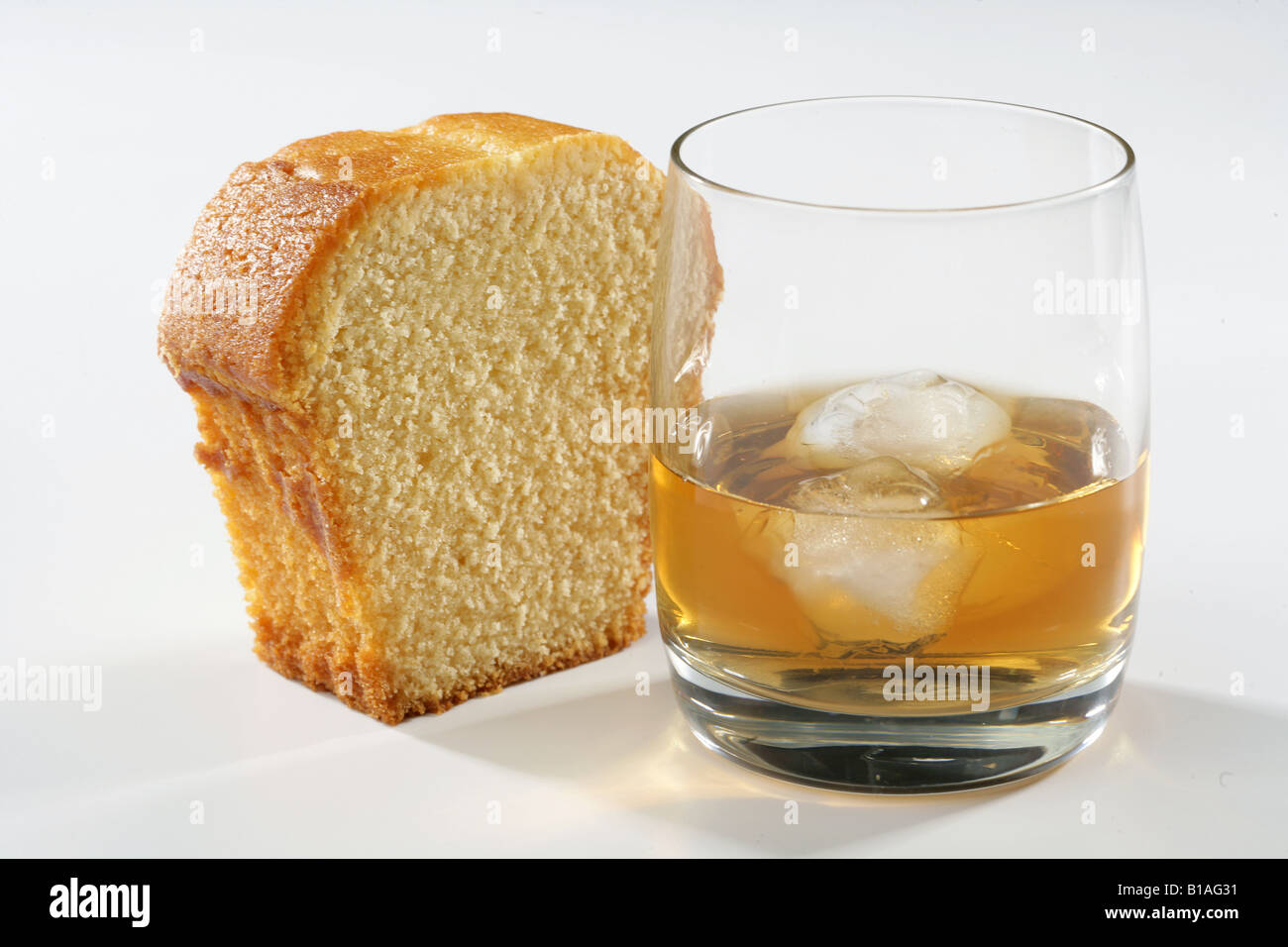 Ein Glas Whisky mit Eis und einem Stück Kuchen Stockfoto