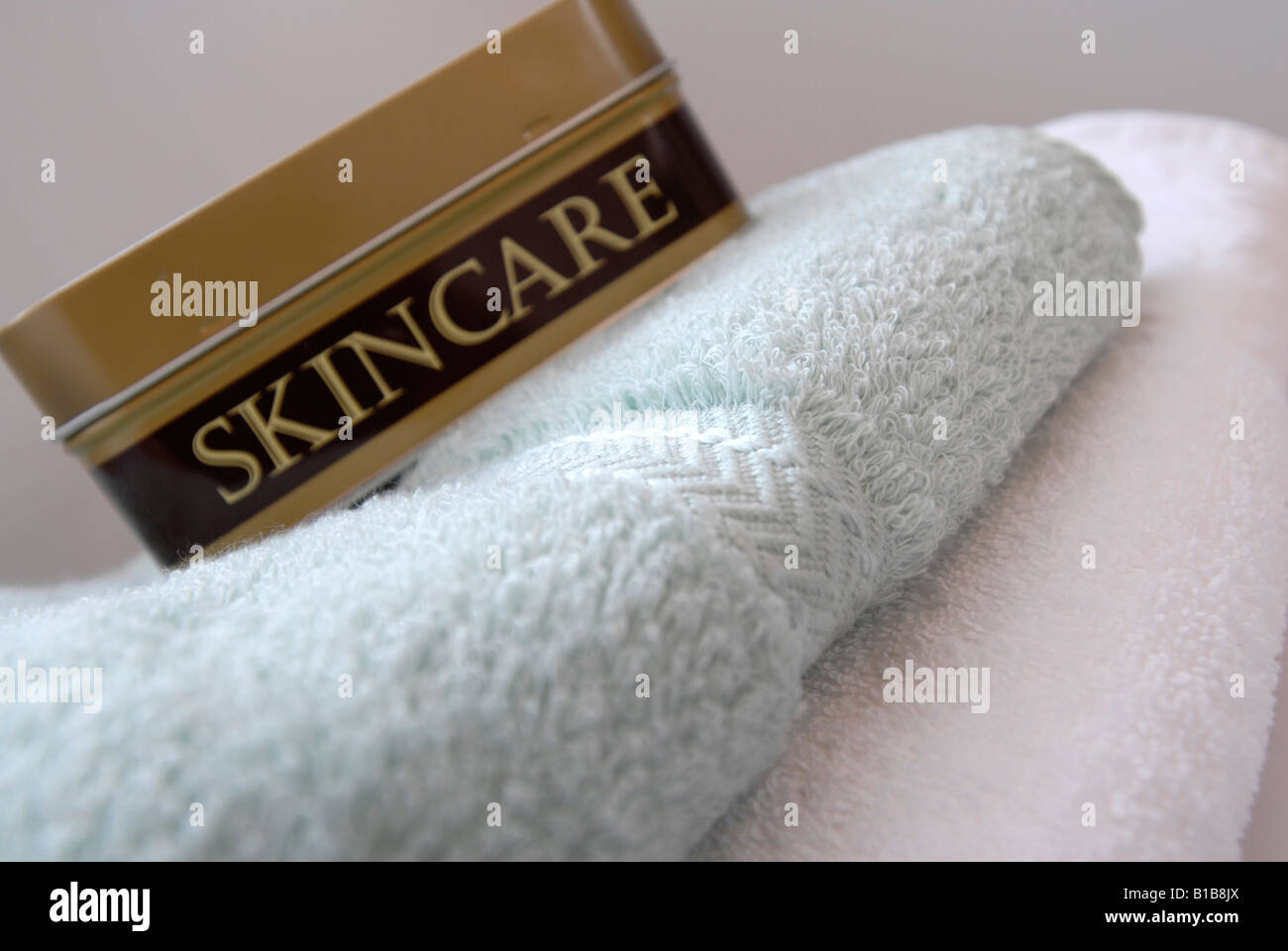 Hautpflege-Produkt-Zinn mit Handtüchern Stockfoto