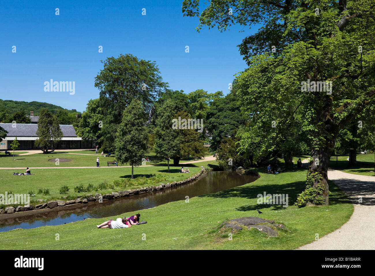 Paar zum Entspannen in der Sonne, dem Pavilion Gardens, Buxton, Peak District, Derbyshire, England Stockfoto