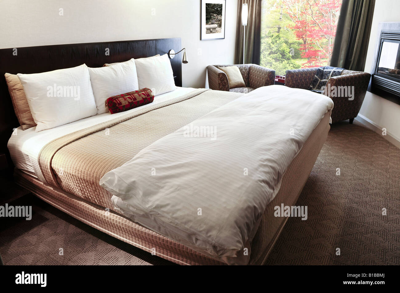 Schlafzimmer mit bequemen Bett in neutralen Farben Stockfoto