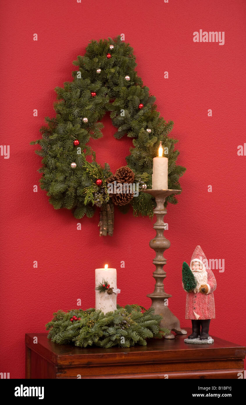 Weihnachtskranz und Dekorationen auf roten Wand Stockfoto