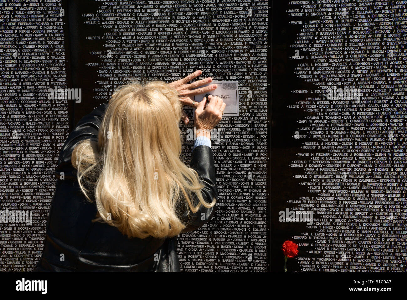 Familienangehöriger eines gefallenen Soldaten in Vietnam-Krieg macht Eindruck des Namens auf Reisen Mauer der Erinnerung Stockfoto