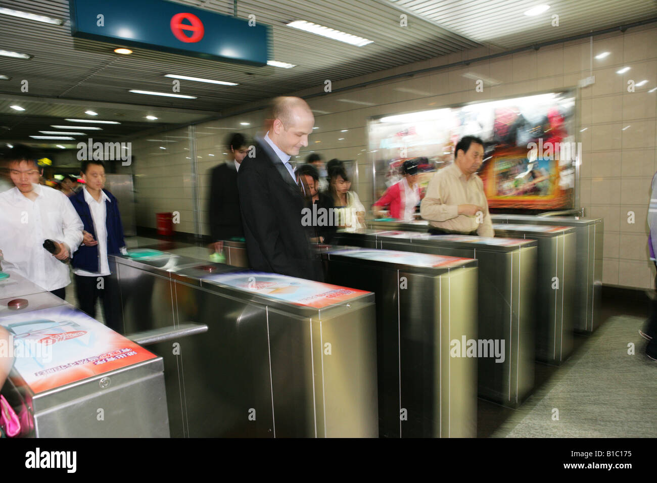 viele Menschen aus verschiedenen Kulturen, die zu Fuß über das Drehkreuz von Subway, Shanghai, China Stockfoto