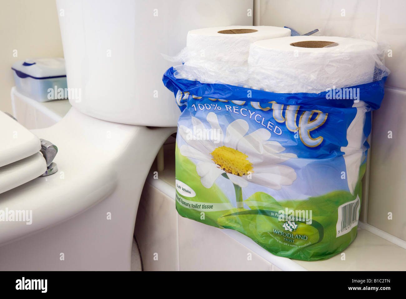 Paket von 100 % Recyclingpapier Gewebe Toilettenpapierrollen neben weißen Keramik Toilette im Badezimmer. England-UK-Großbritannien Stockfoto