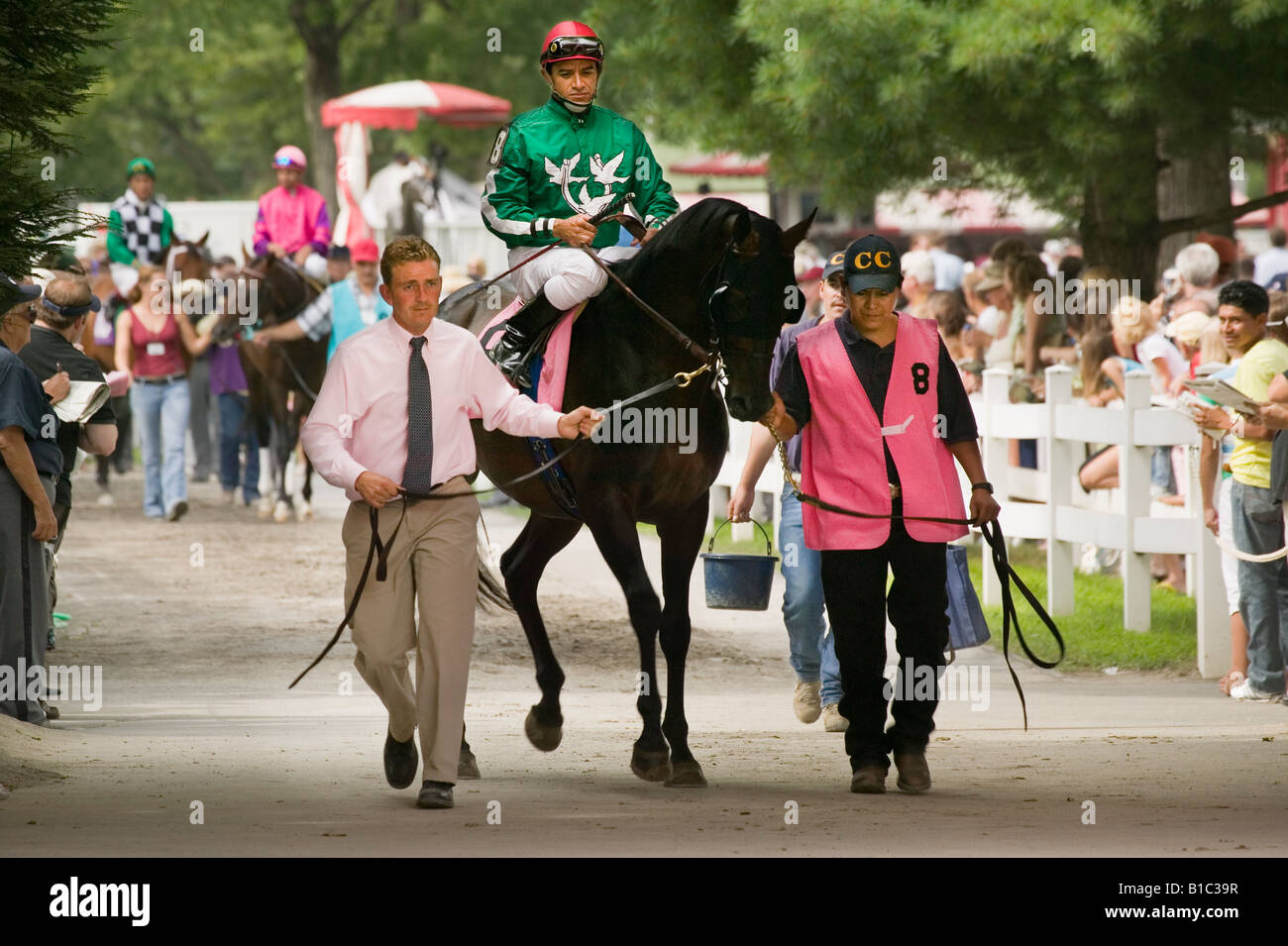 Trainer Walking Pferde und Jockeys vom Fahrerlager, Saratoga Race Course Saratoga Springs New York zu verfolgen Stockfoto