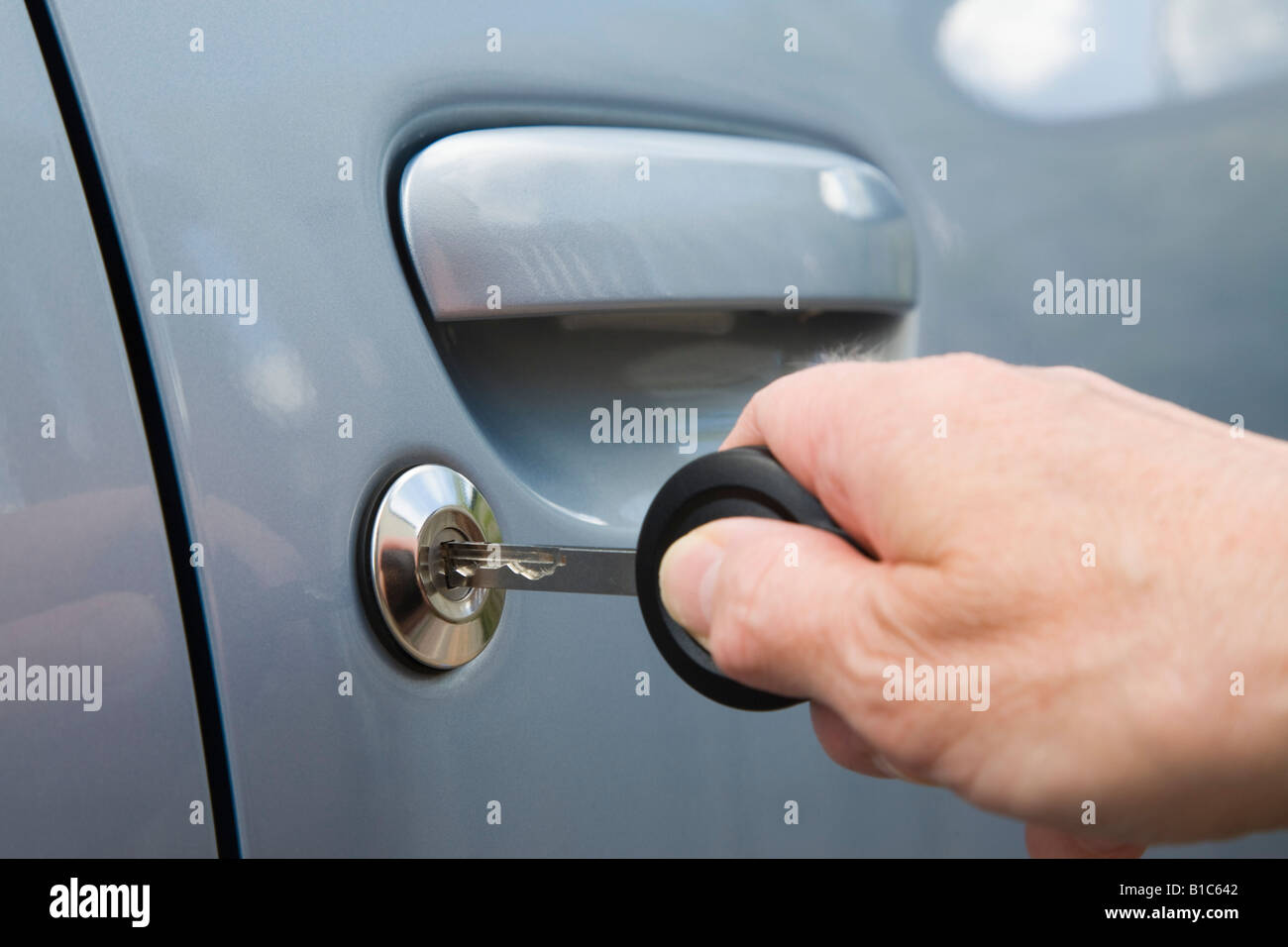 Person, die Autoschlüssel in der hand einlegen Türschloss zu entsperren Stockfoto