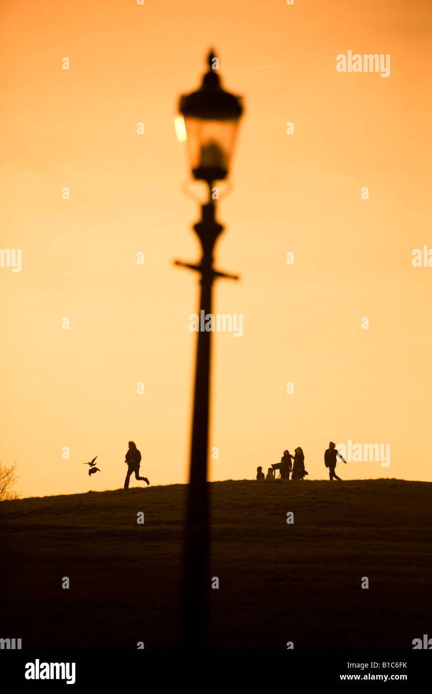 Man jagt Vögel an der Spitze der Primrose Hill bei Sonnenuntergang Stockfoto