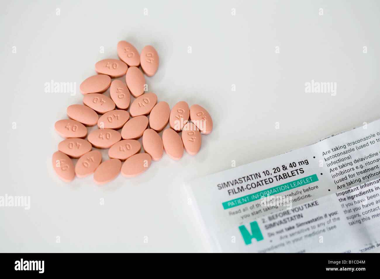 Simvastatin-Pillen in der Form ein Herz, plus ihre Medikamente-Broschüre Stockfoto