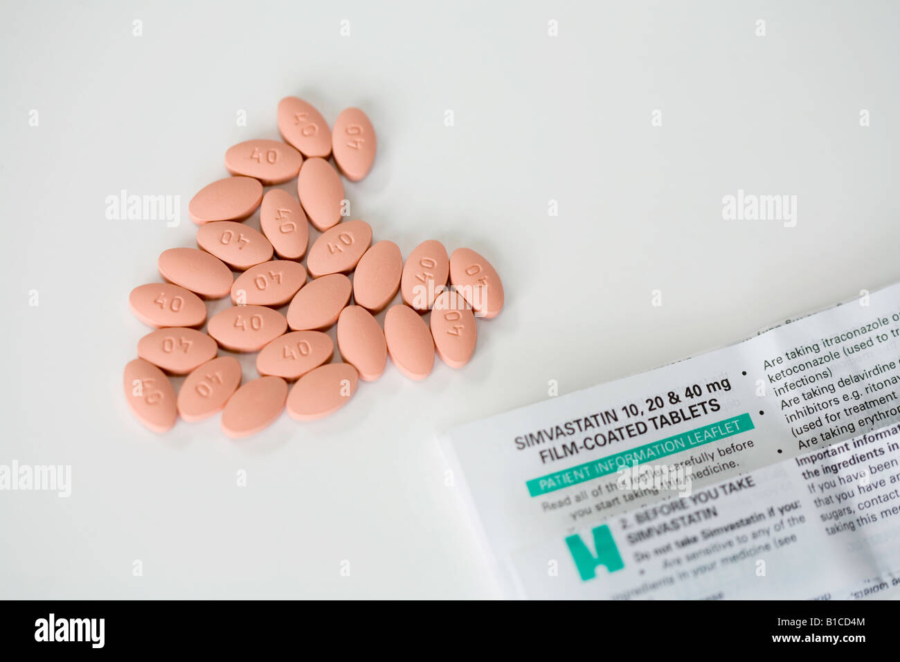 Simvastatin-Pillen in der Form ein Herz, plus ihre Medikamente-Broschüre Stockfoto