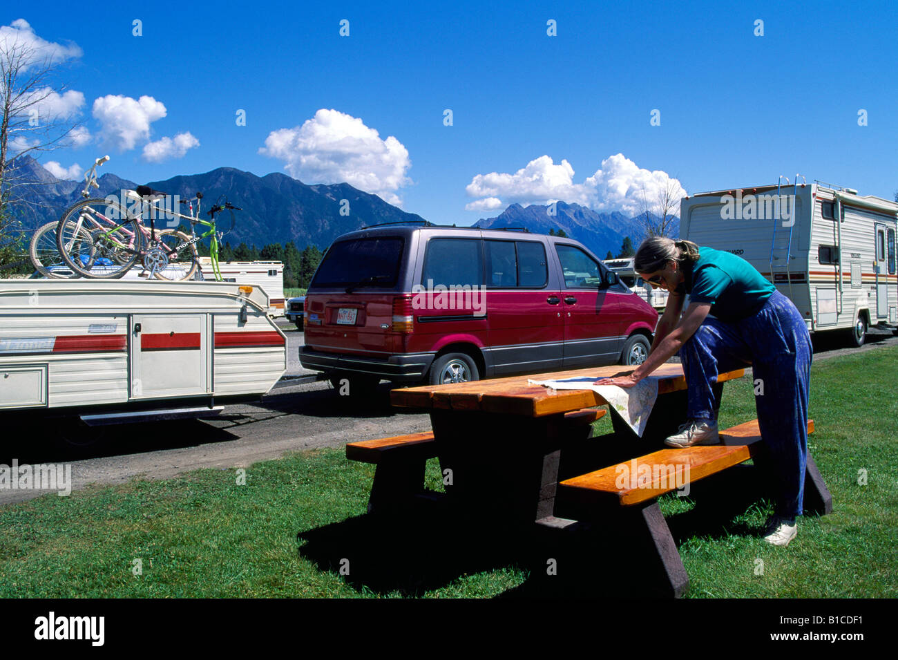 Frau, Kartenlesen und planen Sie eine Reise auf einem Campingplatz in den kanadischen Rocky Mountains in der Nähe von Fort Steele British Columbia Kanada Stockfoto