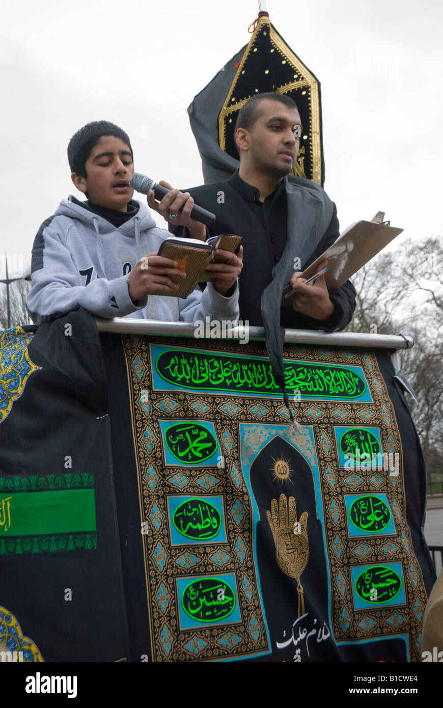 Junger Mann Lesung an der London Arbaeen Prozession, wie Shia Moslems 680 CE Kerbela Massaker Gedenken Stockfoto