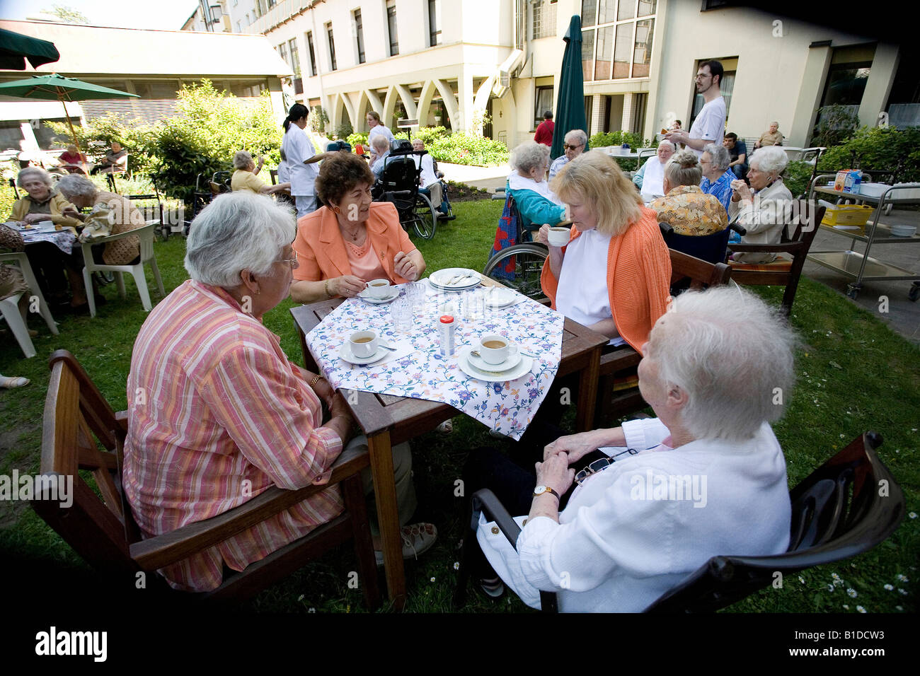 Bewohner der Kindergarten nach Hause Kaffeetrinken in einem Garten eines Kindergartens nach Hause, Mainz, Deutschland Stockfoto