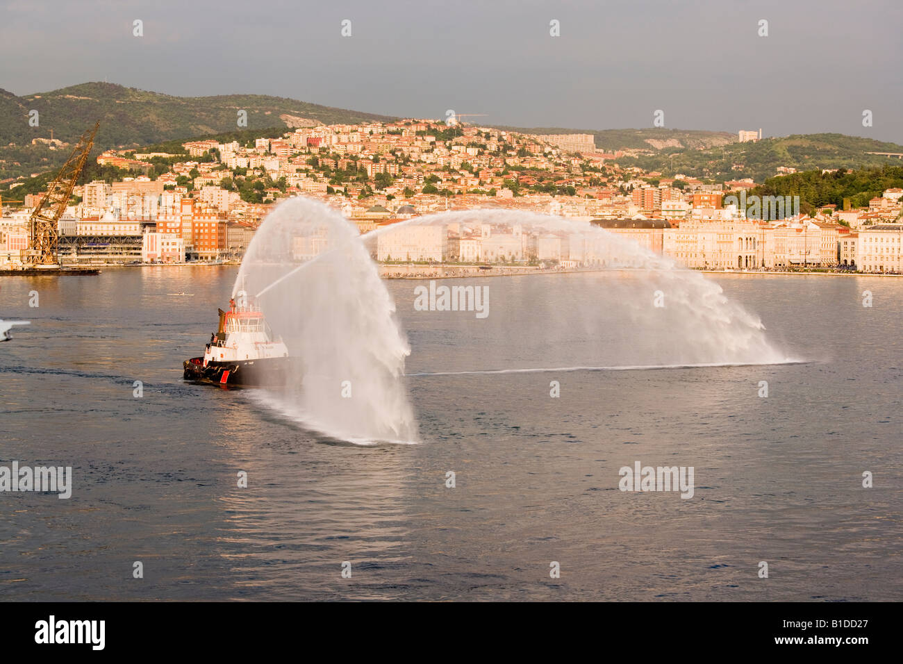 Taur-Schlepper in Triest Italien geben Abschieds-Gruß mit Wasserwerfern Stockfoto