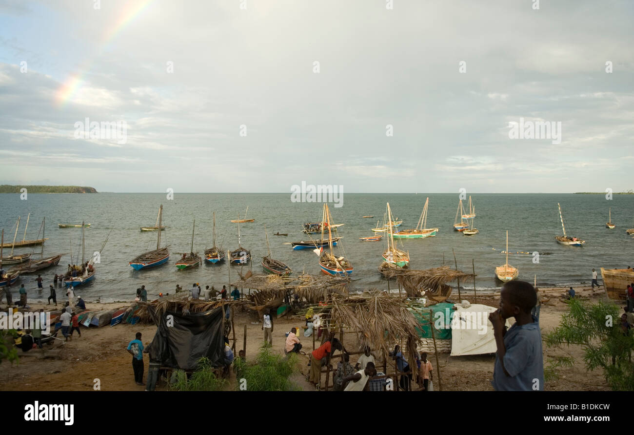 Dhaus bei bewölktem Himmel mit Regenbogen in der Hafen Mocímboa de Praia, Norden Mosambiks festgemacht. Stockfoto