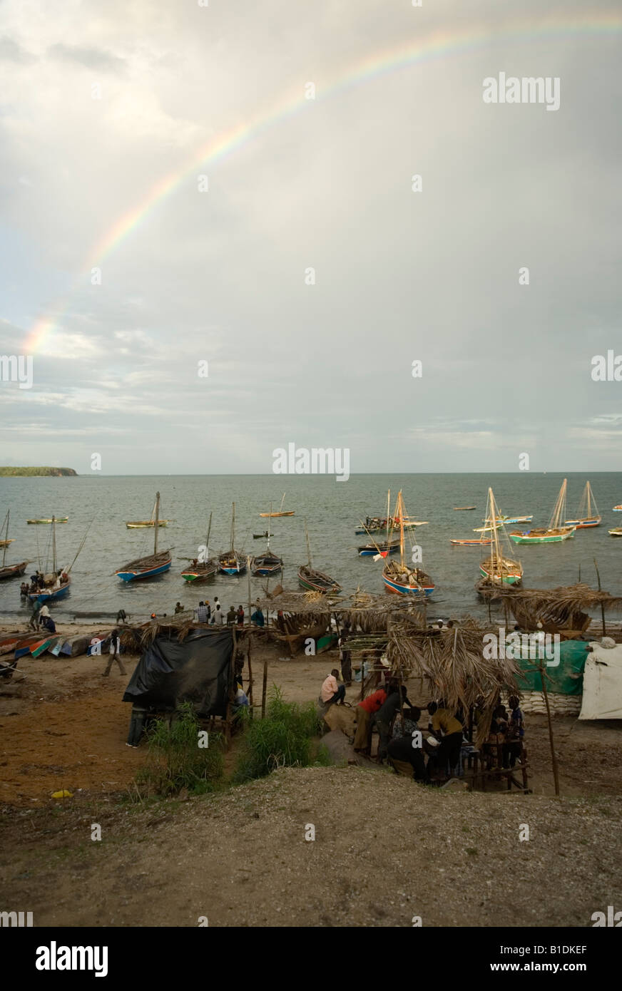 Dhaus bei bewölktem Himmel mit Regenbogen in der Hafen Mocímboa de Praia, Norden Mosambiks festgemacht. Stockfoto