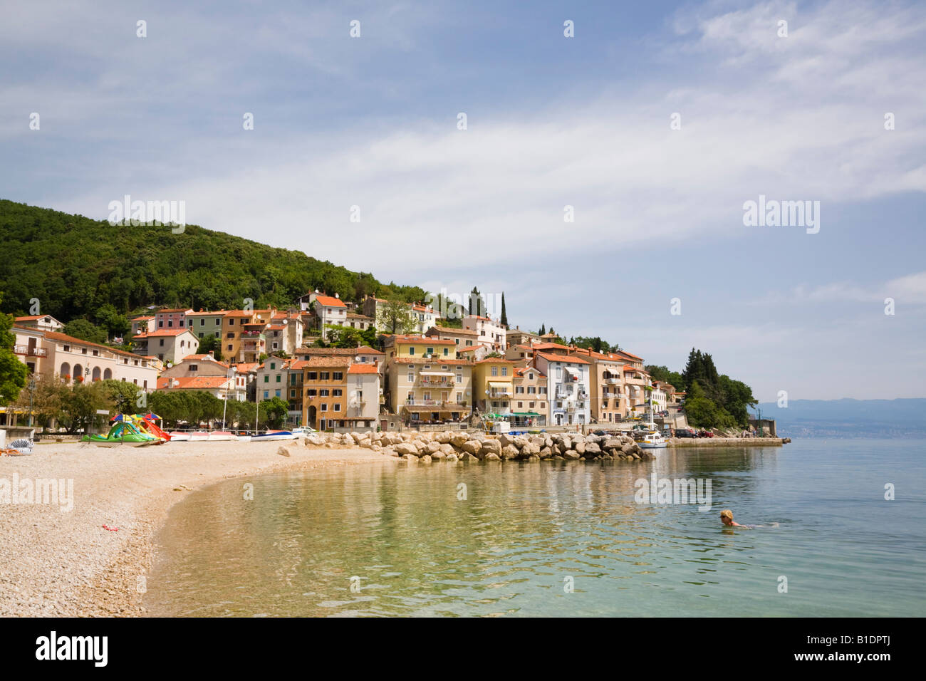 Blick entlang ruhiger Strand, Hafen und Altstadt Gebäude am Hang in Tourist Resort. Moscenicka Draga Istrien Kroatien Stockfoto