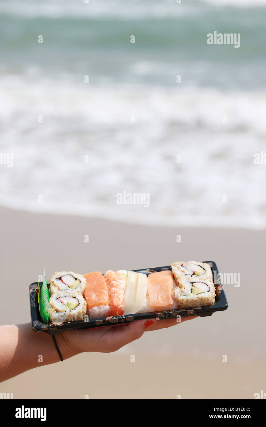 Junge Frau mit Sushi-Modell veröffentlicht Stockfoto