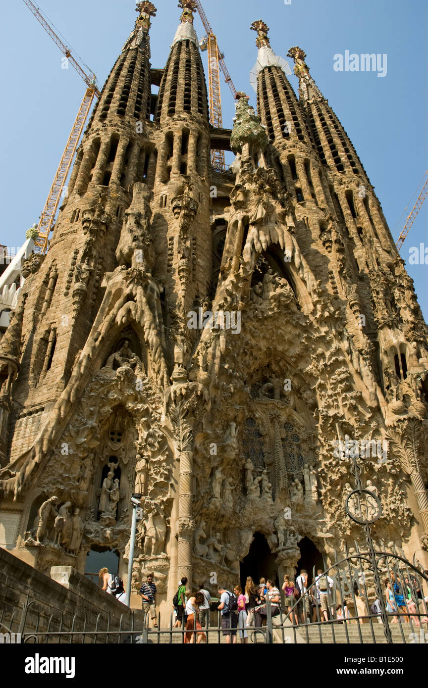 Touristen vor dem Eingang zu Antoni Gaudis La Sagrada Familia zu bewundern, Statuen Schnitzereien und Figuren an der Fassade der Geburt Christi Stockfoto