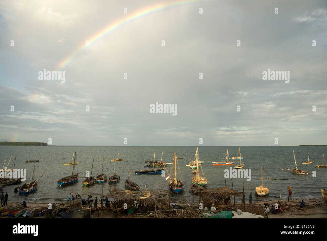 Dhaus bei bewölktem Himmel mit Regenbogen in der Hafen Mocímboa de Praia, Norden Mosambiks festgemacht. Stockfoto