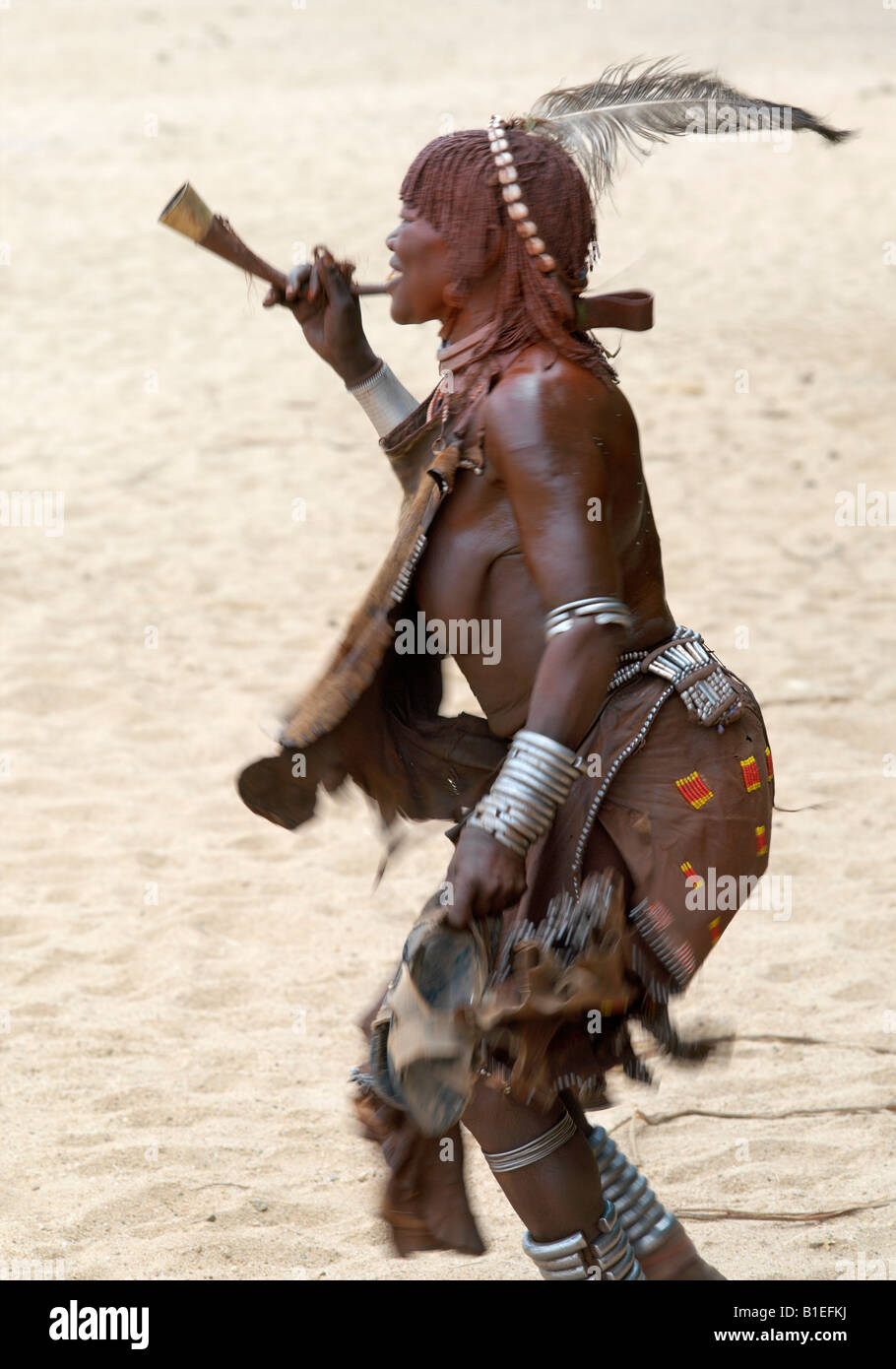 Eine alte Frau von Hamar tanzt und bläst eine Trompete "Jumping des Stieres" Preisverleihung. Die Hamar sind semi-nomadische Hirten. Stockfoto