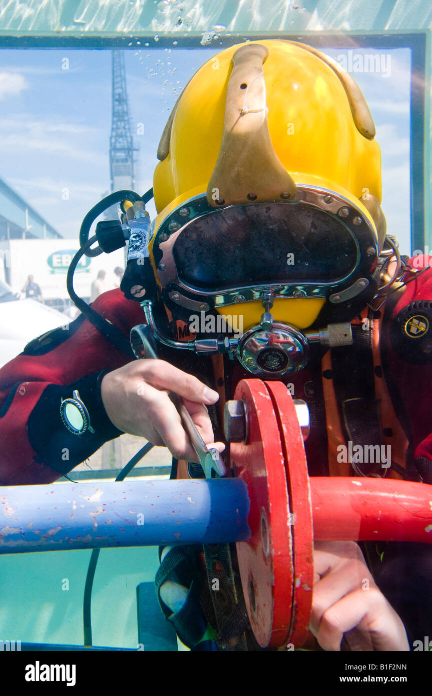 Taucher tragen Aqualung Demonstration der Arbeiten unter Wasser verbinden einen Flansch zu geben. Aufgenommen auf einer Messe. Stockfoto