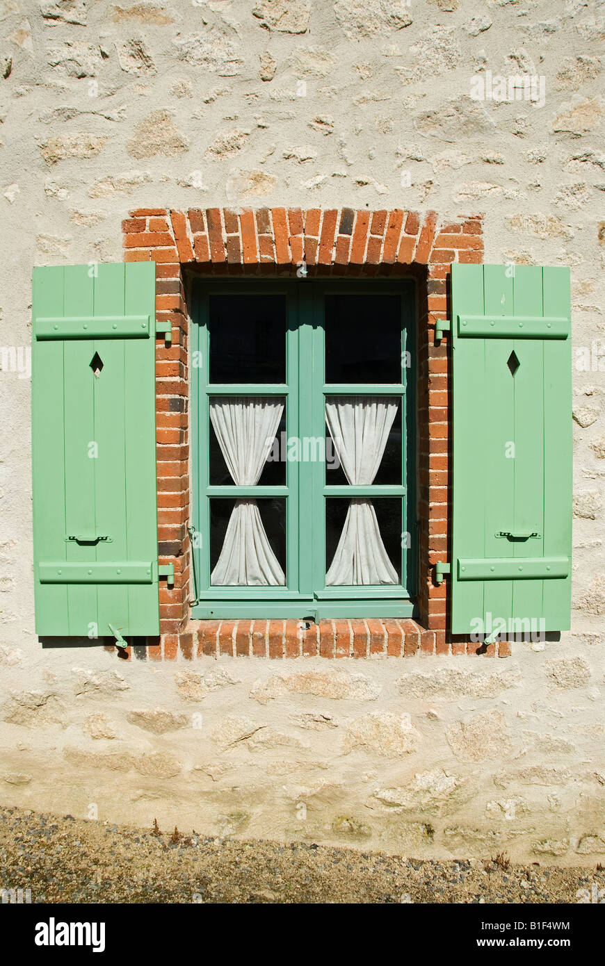 Stock Foto eines Fensters mit hübschen grünen Fensterläden aus Holz Stockfoto