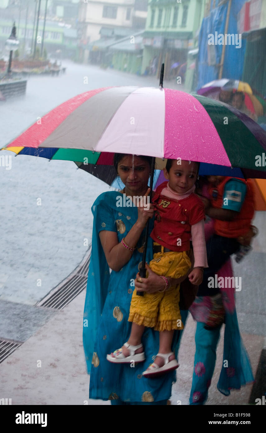 Indische Frau, die ihr Kind zu Beginn der Monsun-Regenfälle in Gangtok, Sikkim Stockfoto