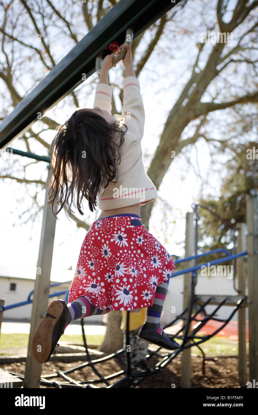 Vier Jahre altes Mädchen aus Klettergerüst in ein Abenteuer-Spielplatz hängt Stockfoto