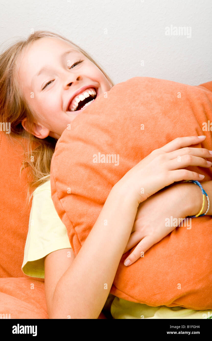 junge blonde Mädchen auf eine orange gemütlich Stockfoto