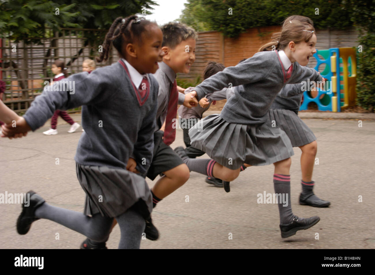 Gruppe von Kindern auf dem Spielplatz eine Private Schule laufen Stockfoto
