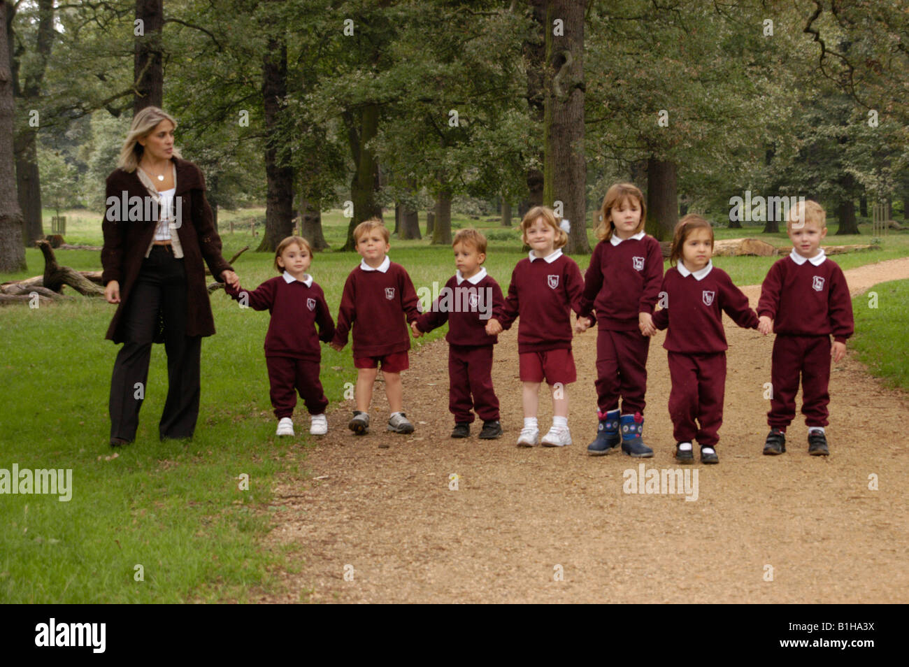 Kinder im Grundschulalter im Park mit ihrem Lehrer Stockfoto