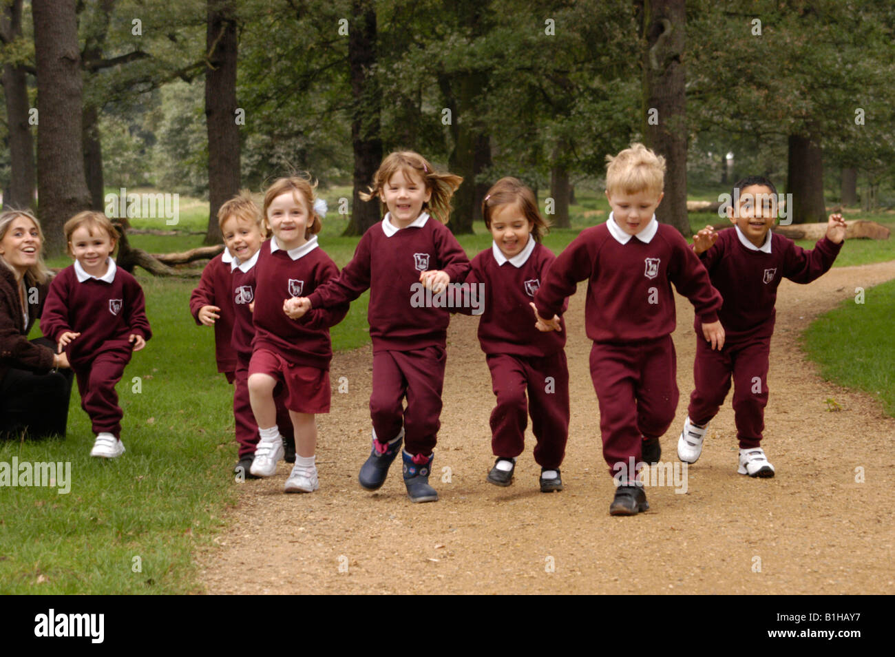Gruppe von Grundschulkindern in den Park, die Hand in Hand laufen Stockfoto