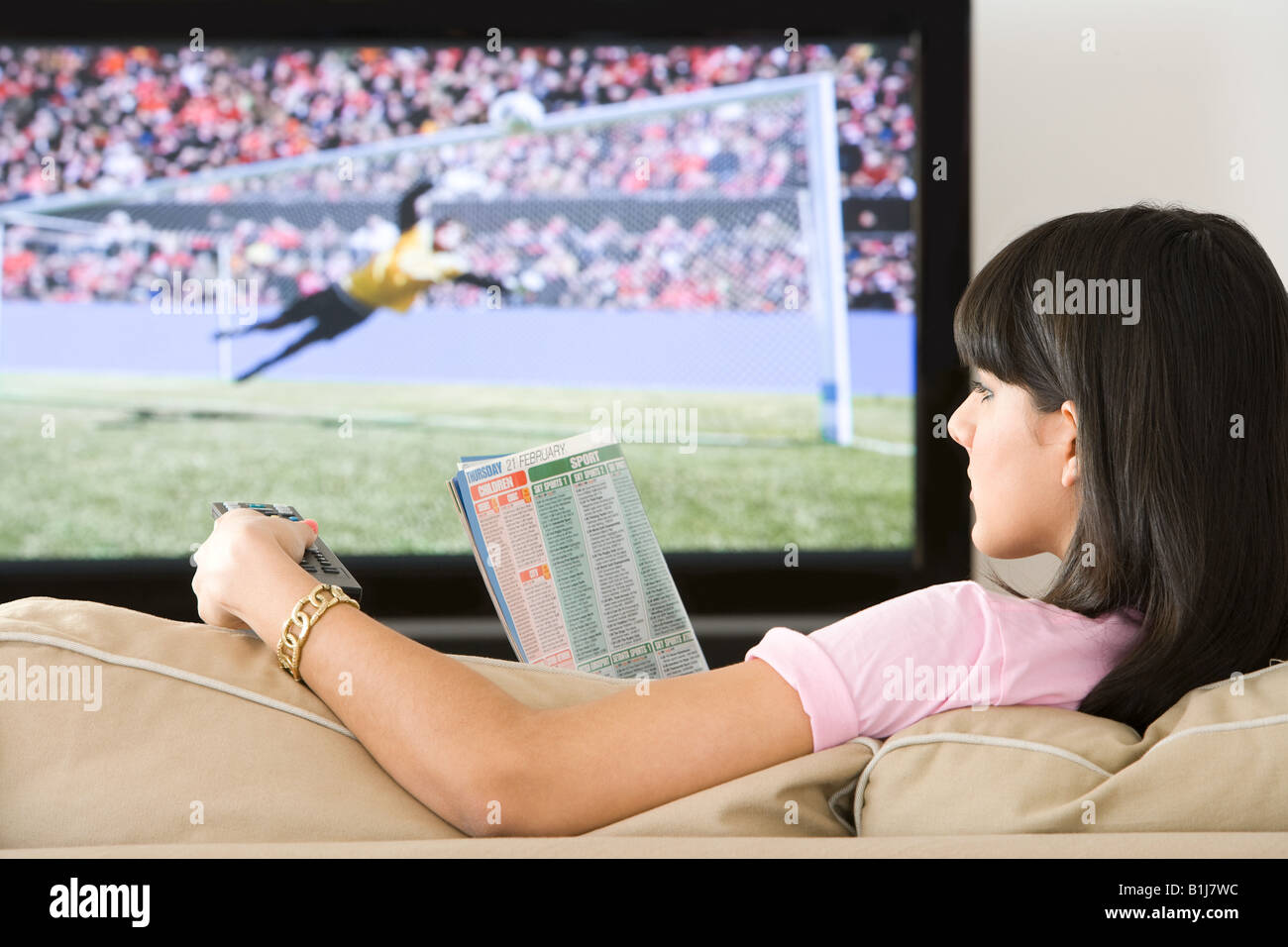 Eine Frau liest eine tv Inserate Magazin Stockfoto